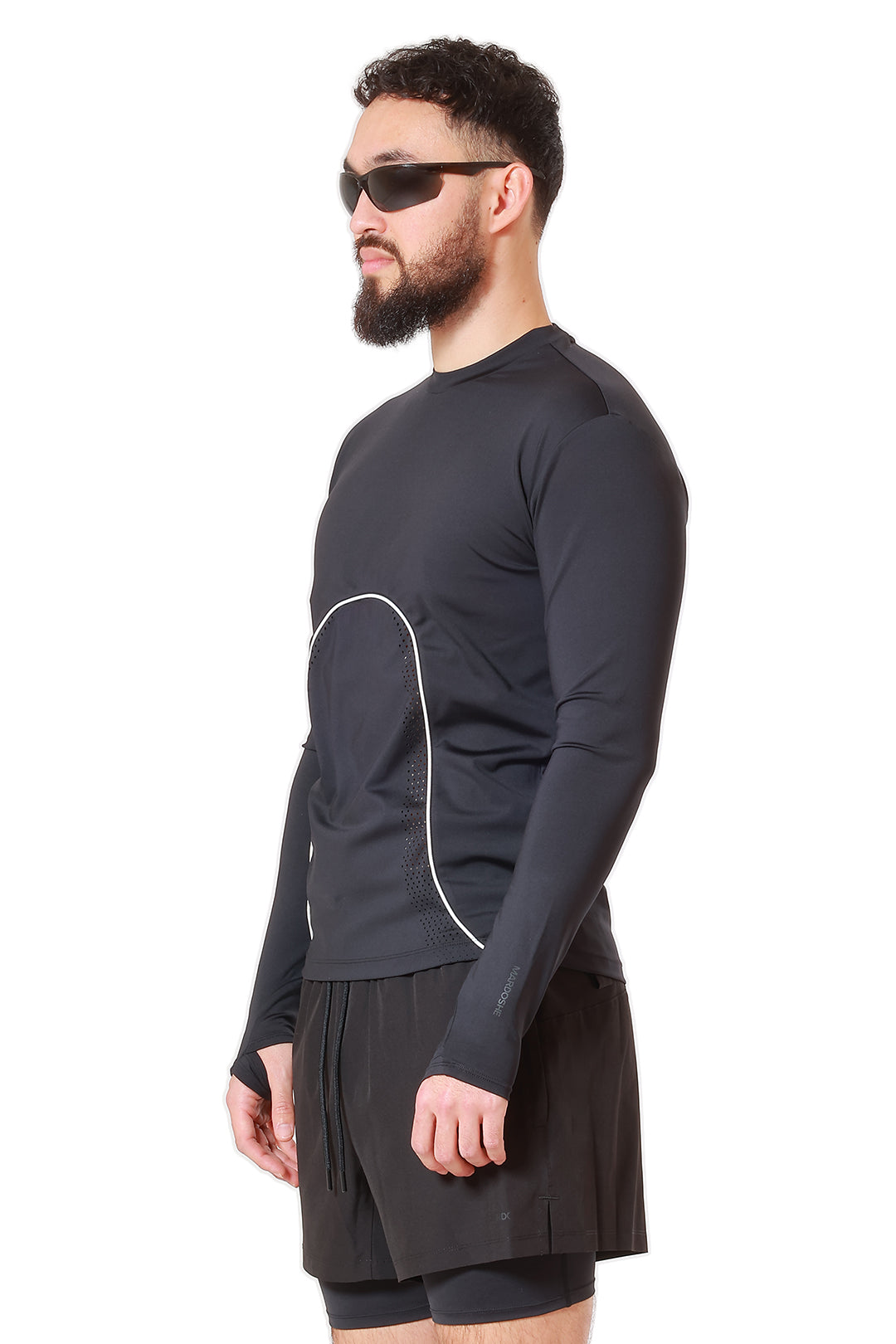 Man wearing a black long-sleeve athletic shirt and shorts on a white background