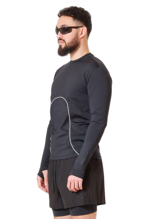 Man wearing a black long-sleeve athletic shirt and shorts on a white background