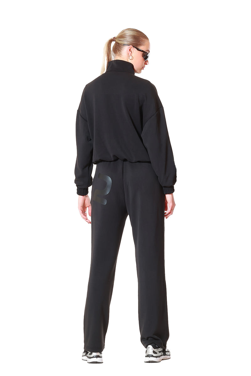 Person wearing a black tracksuit on a white background