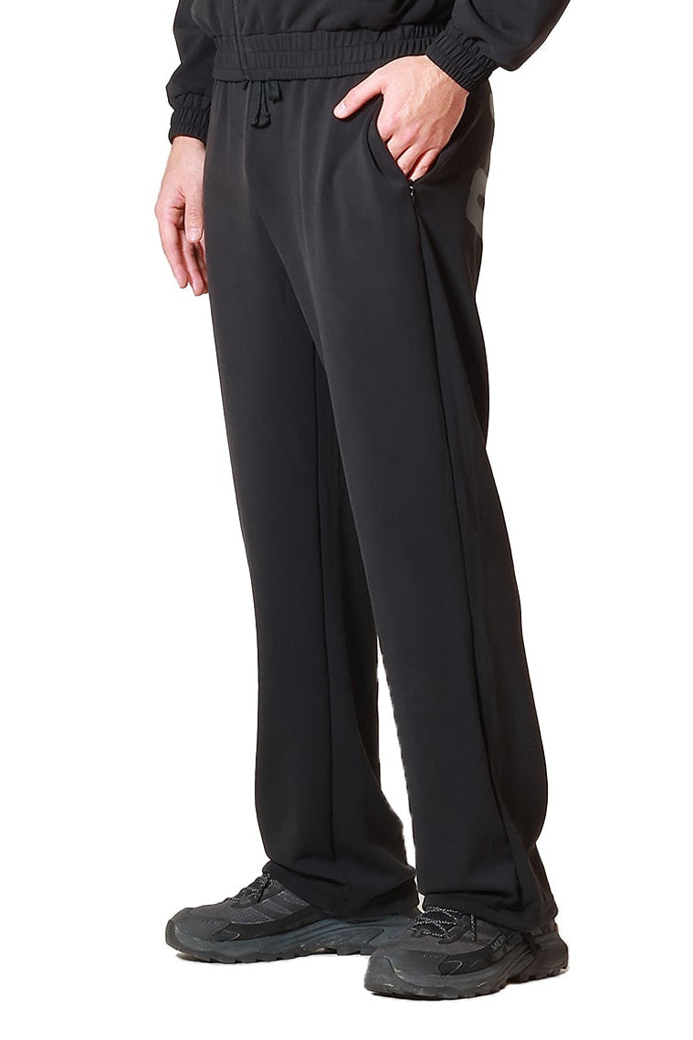 Man wearing a black outfit with sunglasses and a beanie on a white background