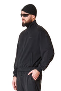Man wearing a black outfit with sunglasses and a beanie on a white background